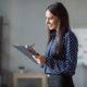 Image of a business person checking off a list on a clipboard.