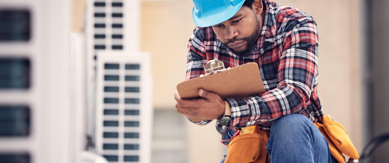 Image of a worker inspecting an HVAC system.
