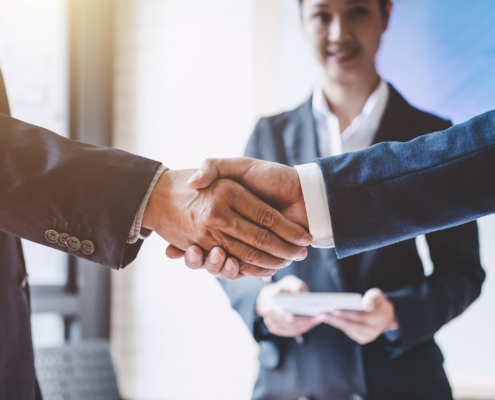 Side view of two people shaking hands