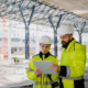 Engineers discussing construction plans using a tablet on site