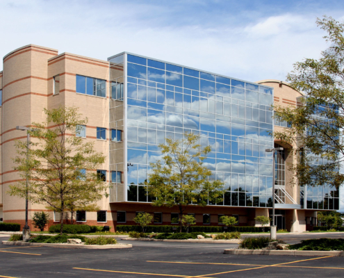An office building with glass windows on a sunny day