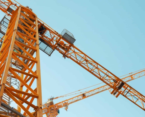 Modern Yellow Construction Cranes Above Blue Sky.jpg